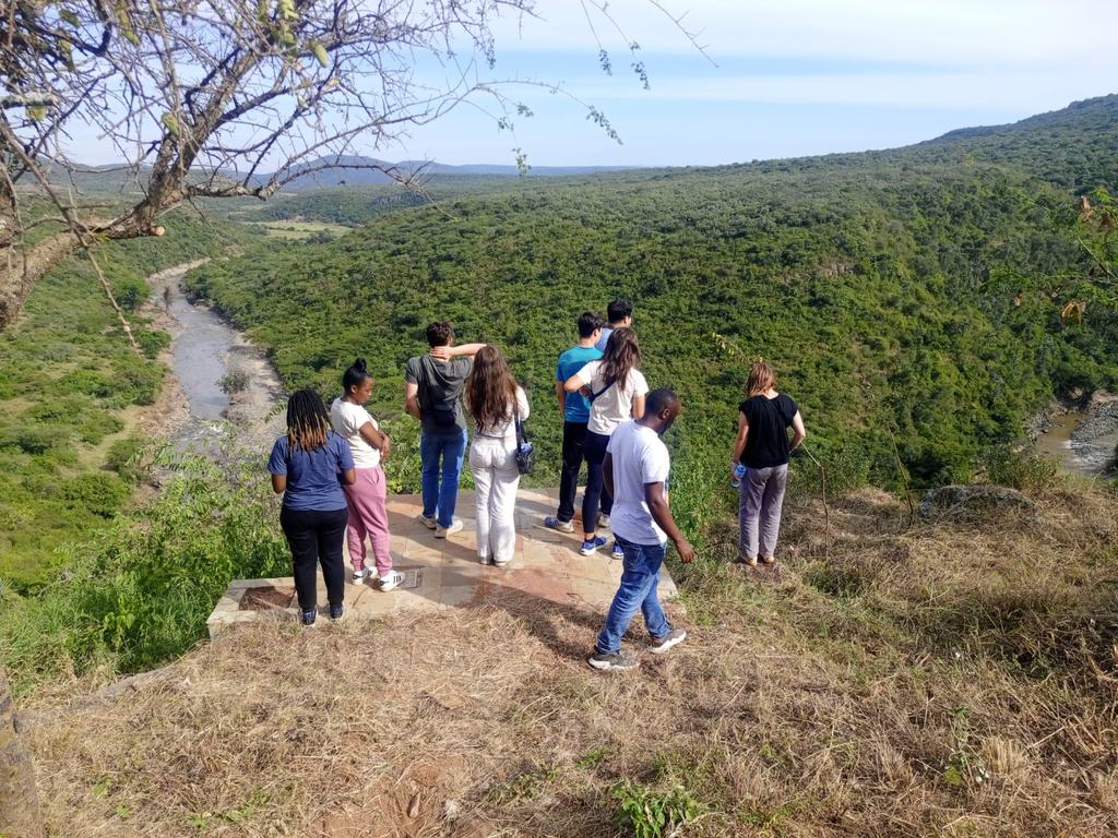 Visitors standing at a canyon viewpoint looking out over the river valley